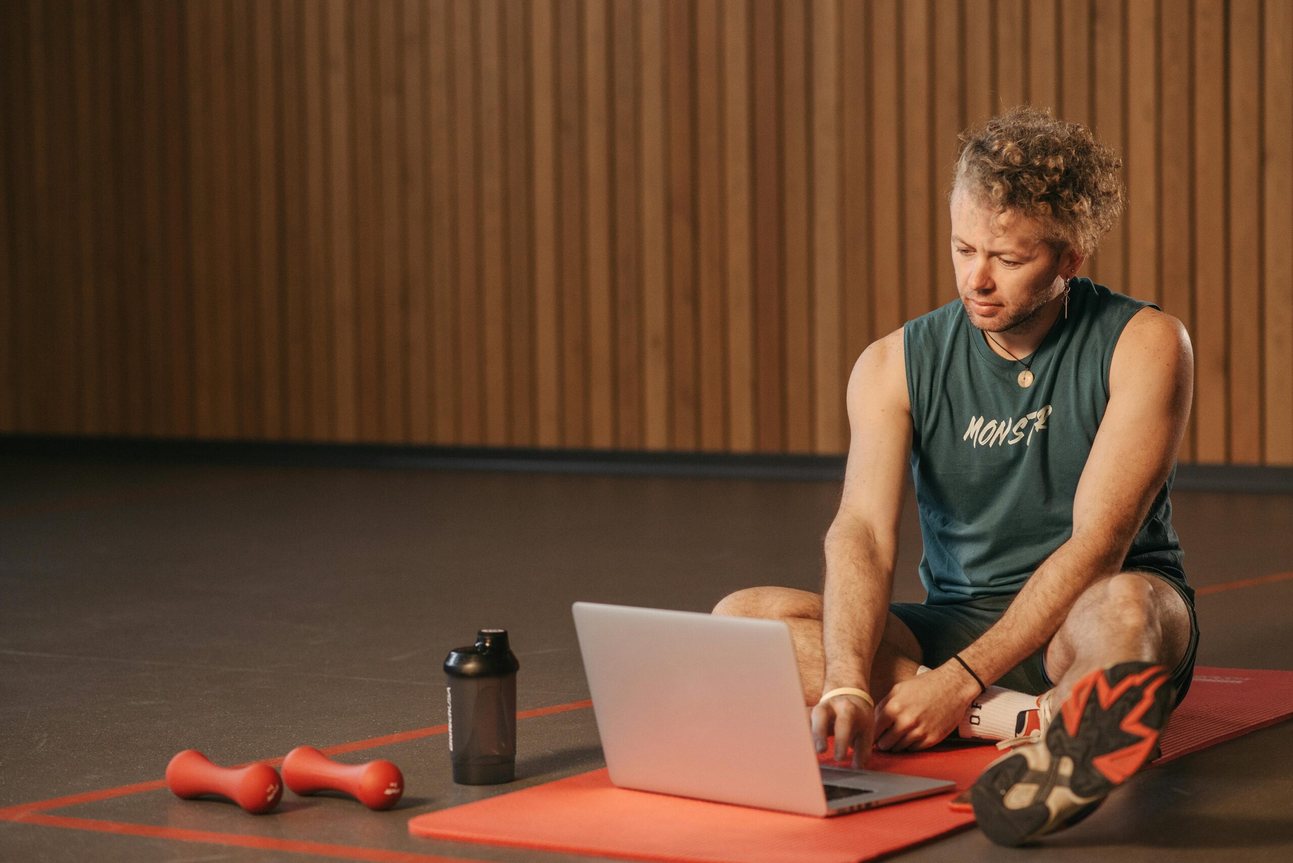 a fitness trainer giving PT online using a laptop and minimal